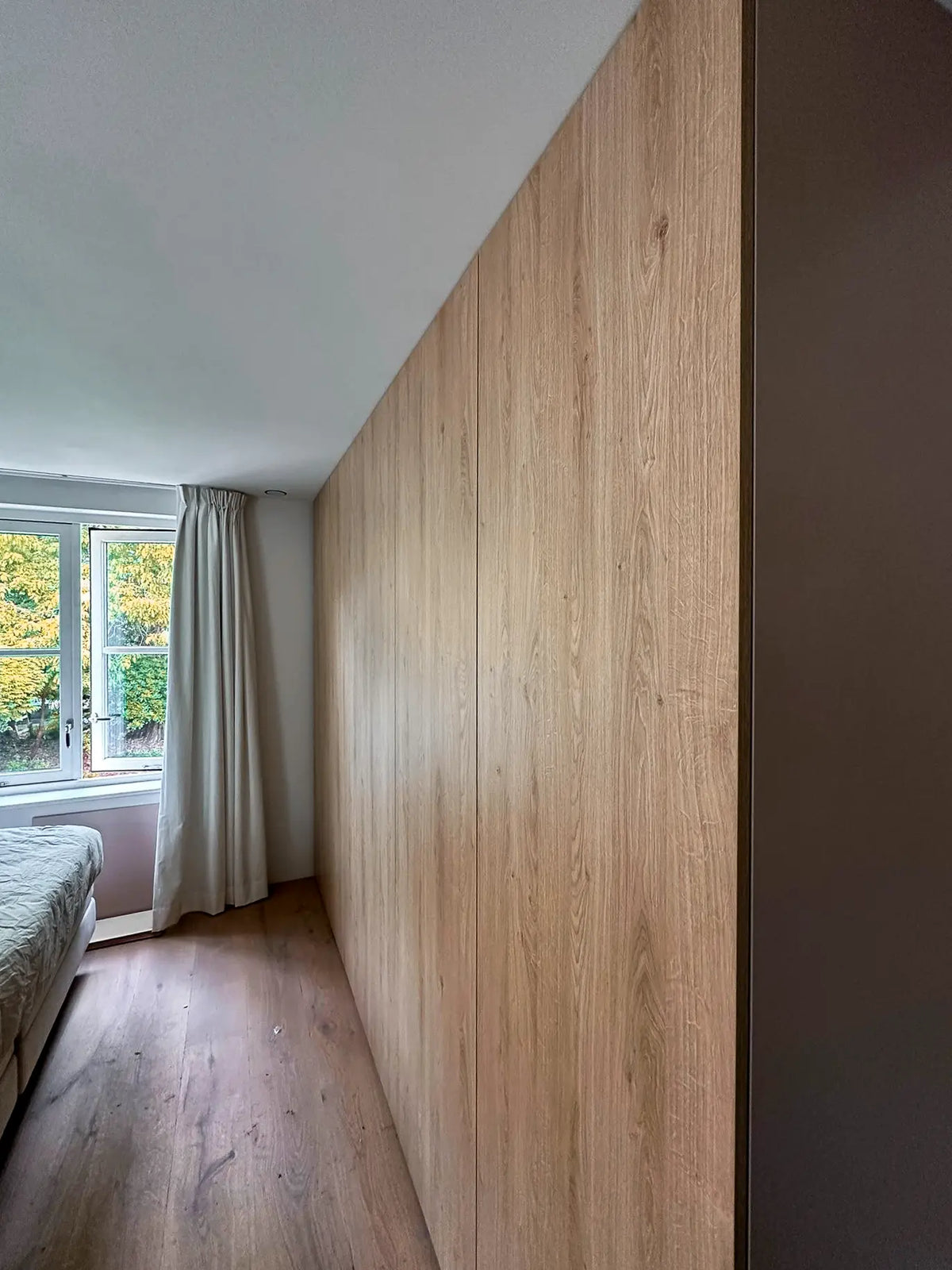 Houten garderobekast op maat van Lundia langs de slaapkamerwand