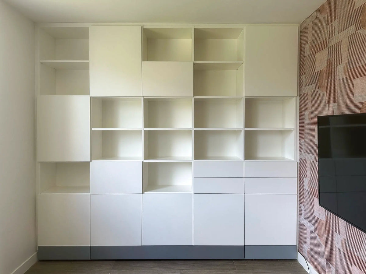 Witte boekenwandkast op maat van Lundia in een nis met open en gesloten vakken