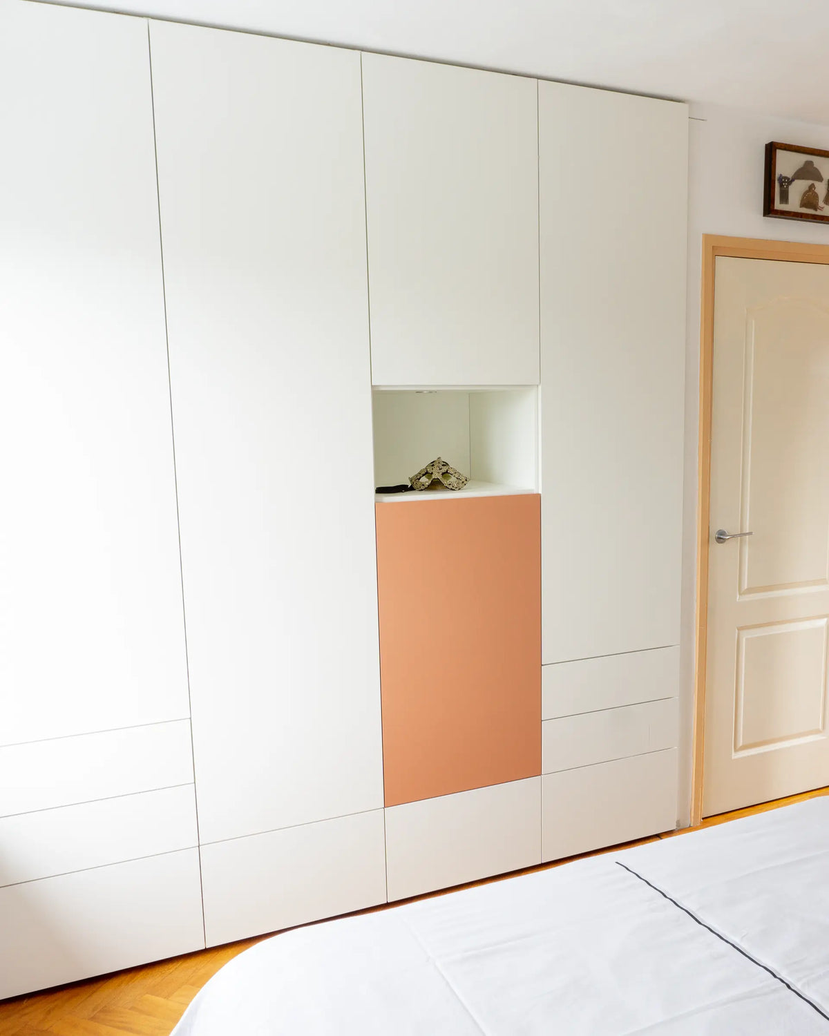 Witte garderobekast op maat van Lundia met terracotta accent in de nis